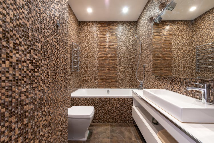 Bathtub And Sink In Modern Bathroom With Mosaic Tiled Walls