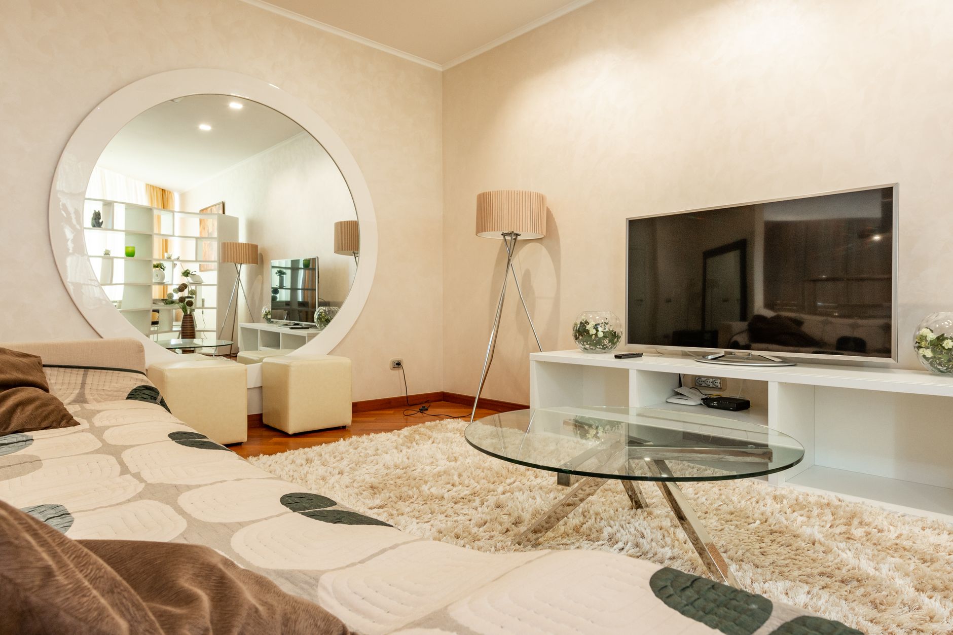 Interior of modern living room with round shaped mirror and couch with pattern