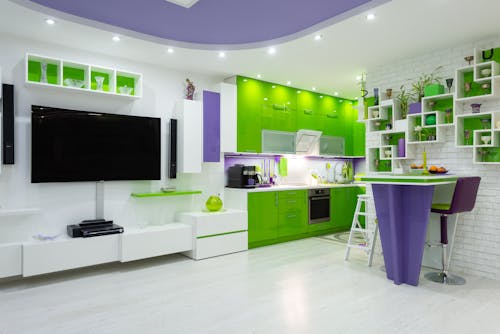 Bright green and purple furniture in contemporary studio apartment with kitchen area