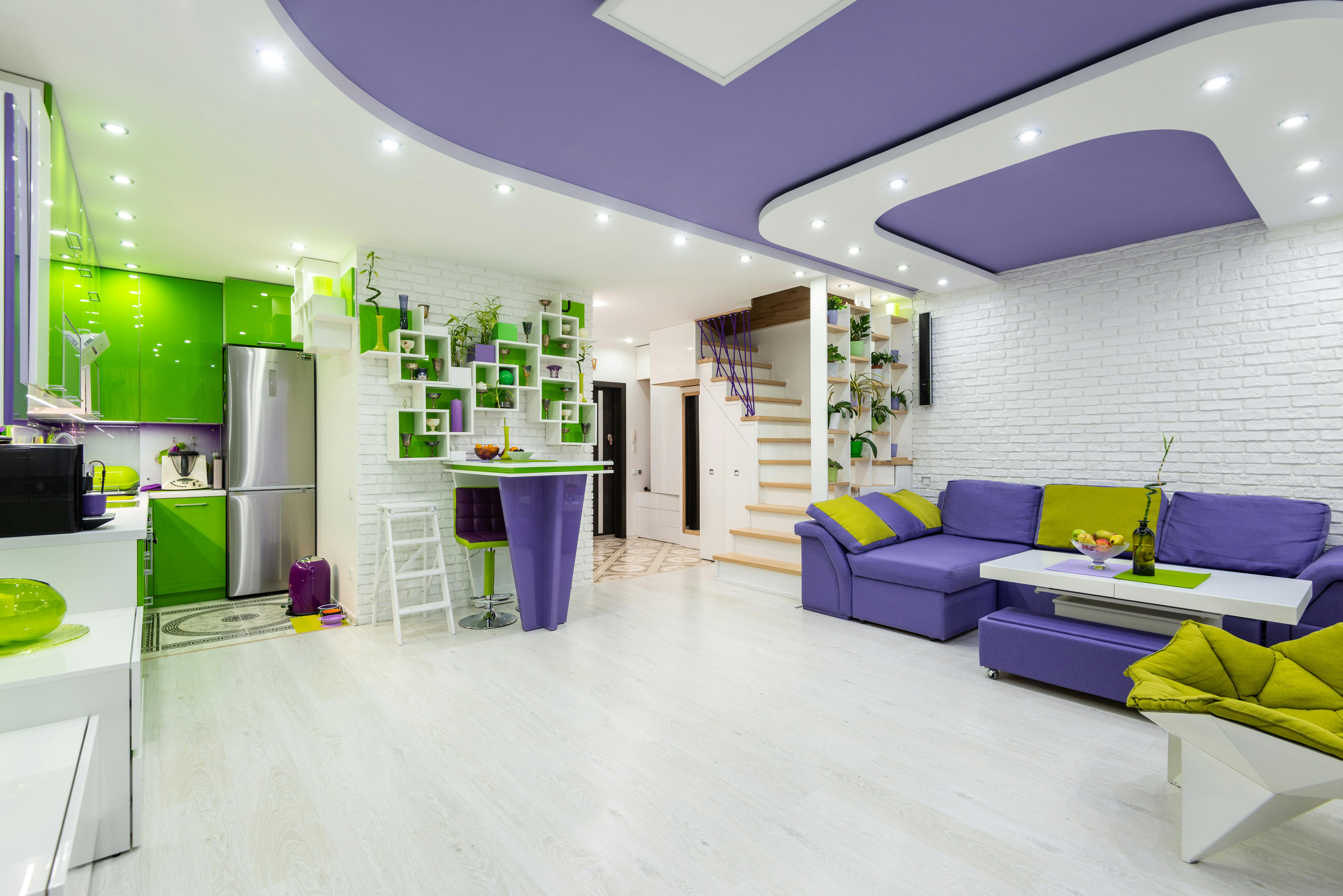 spacious living room with trendy design and kitchen zone with bright green furniture