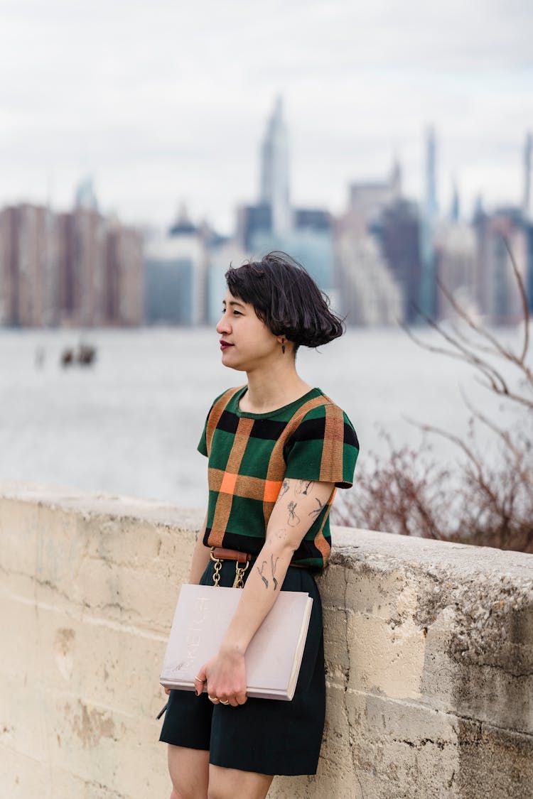 Asian Woman With Notebook On Waterside