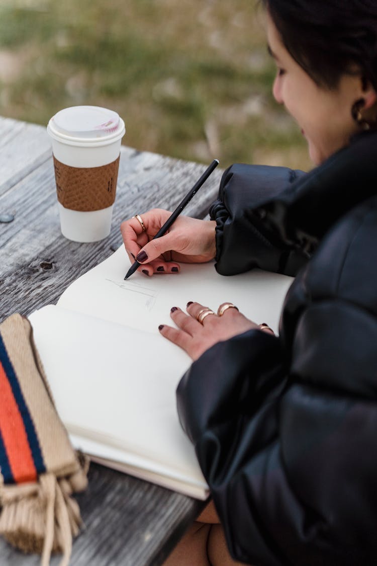 Crop Asian Student Drawing In Notebook At Table In Park