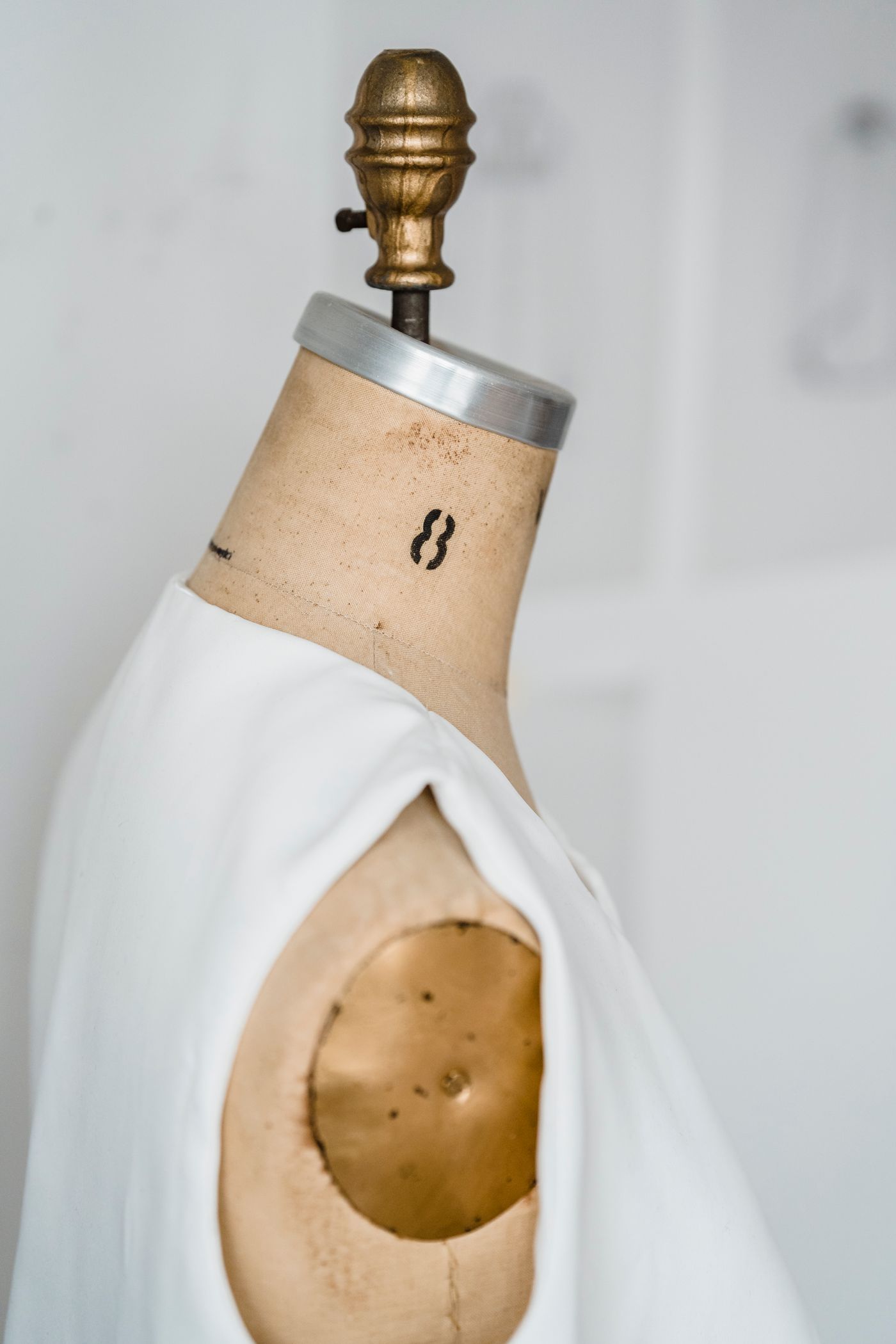 A mannequin draped with cloth in a bright atelier