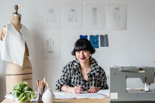 Female tailor smiling and sitting at table