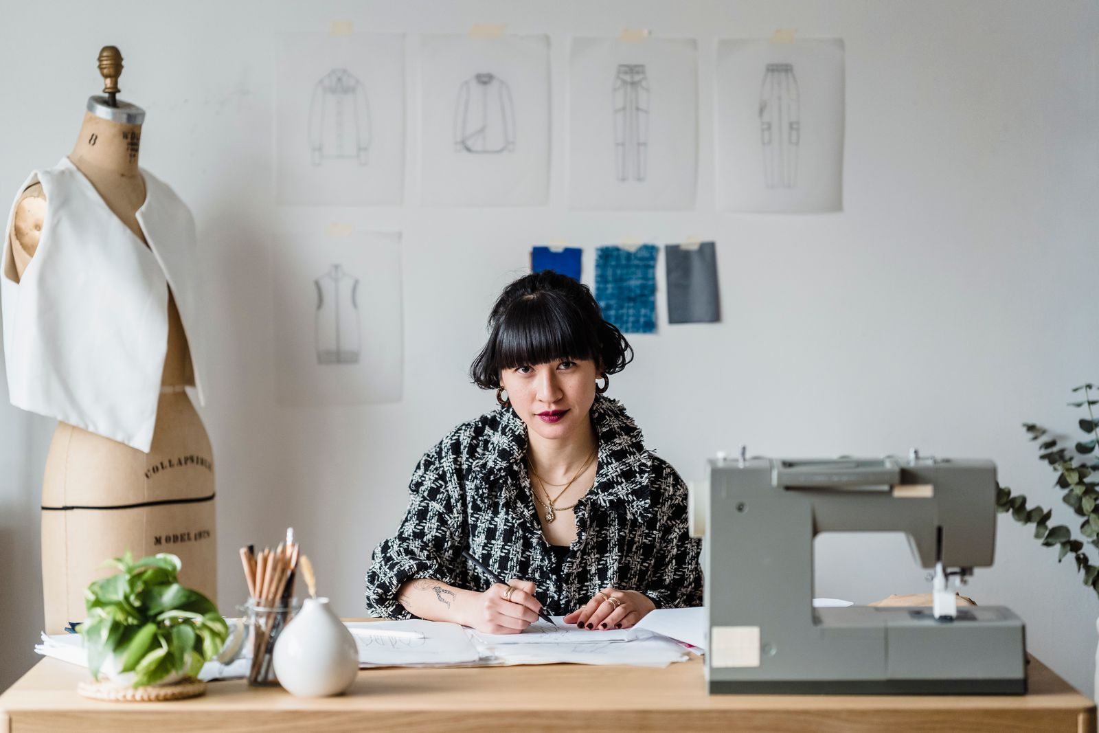 Designer at a table with sewing machine and mannequin