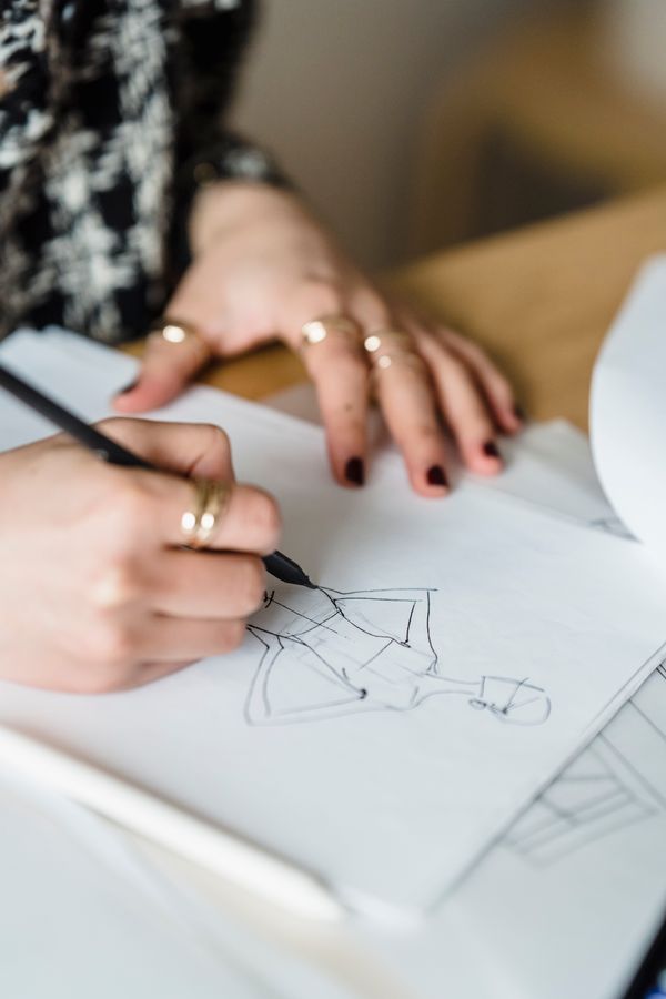 Close-up of hands sketching a dress design
