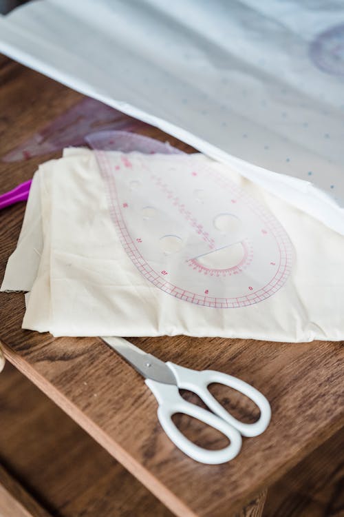 Sewing tools on paper and fabric on table in atelier