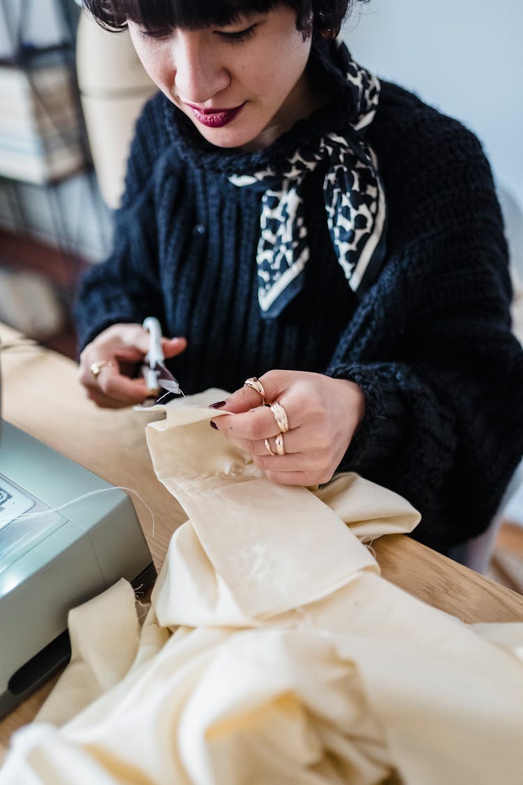 Asian Woman Cutting Fabric In Workshop