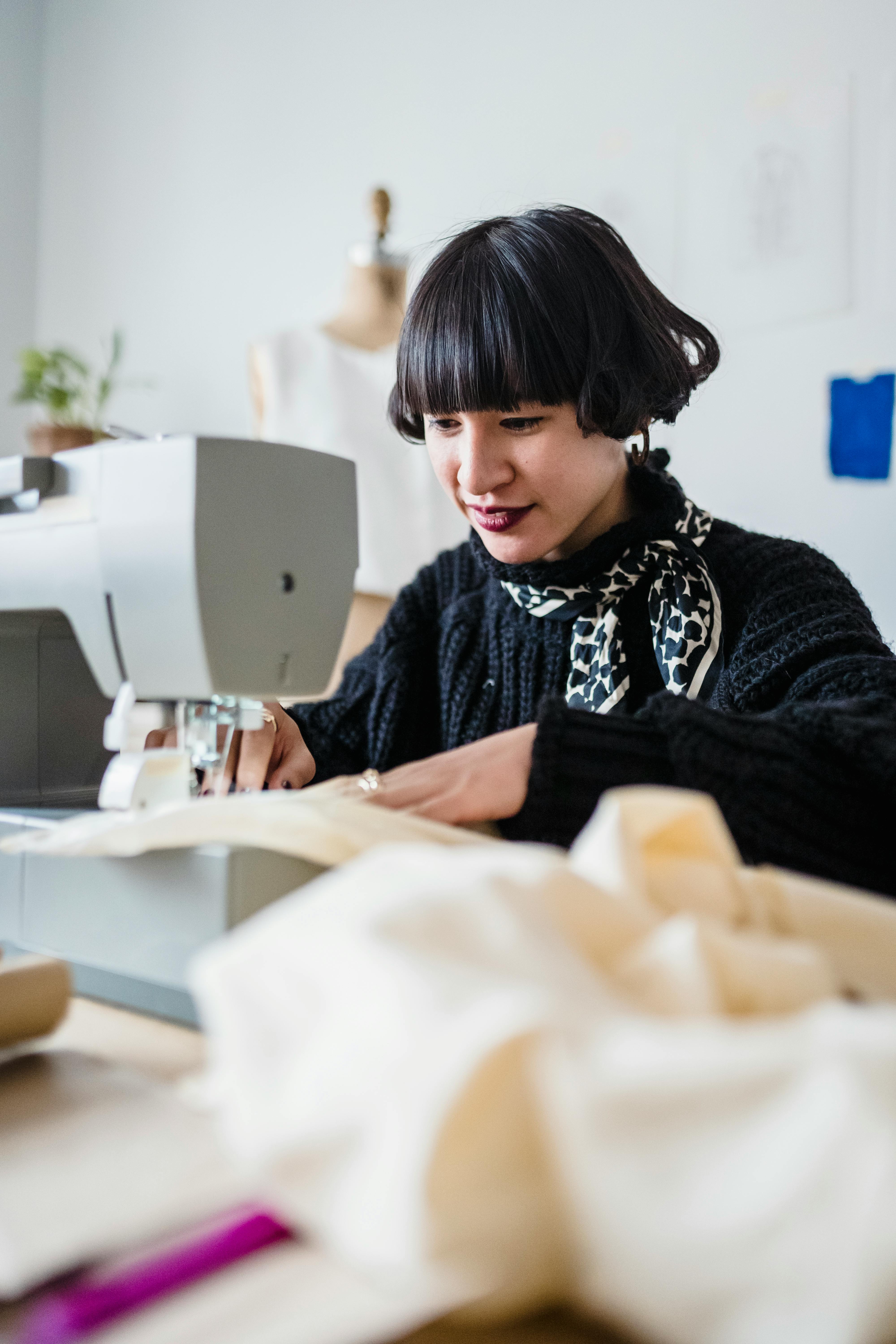 concentrated asian woman sewing fabric