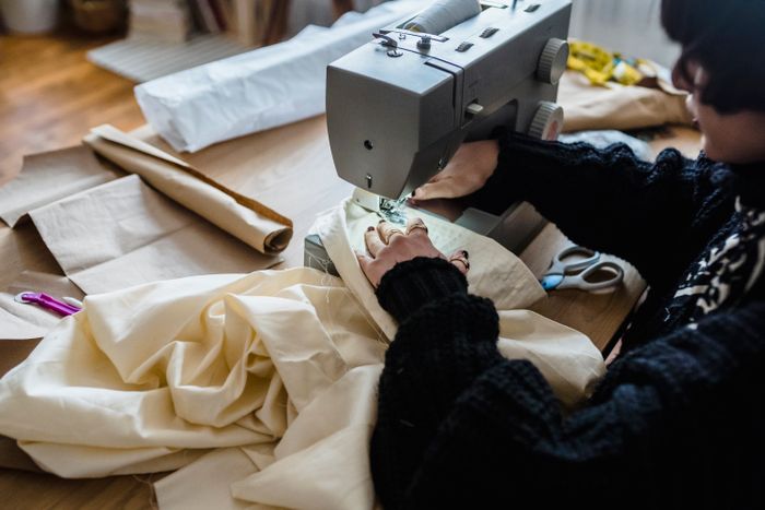 Seamstress finishing a garment on a sewing machine