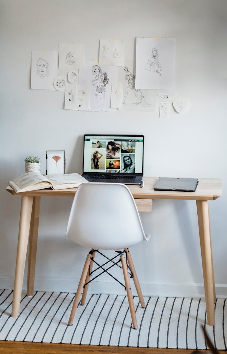 Work Desk With Laptop And Book In Light Room