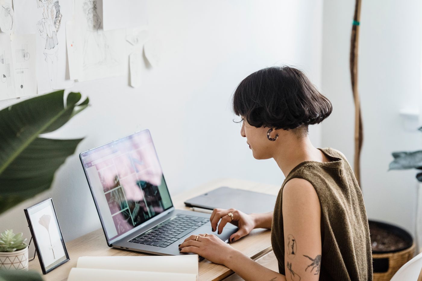 Female designer working on laptop in modern creative studio