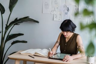 Artist sketching with a graphics tablet in a creative workspace — photo by Michael Burrows on Pexels