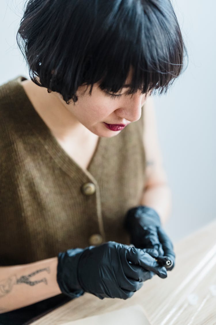 Asian Female In Gloves With Tattoo Machine In Hands