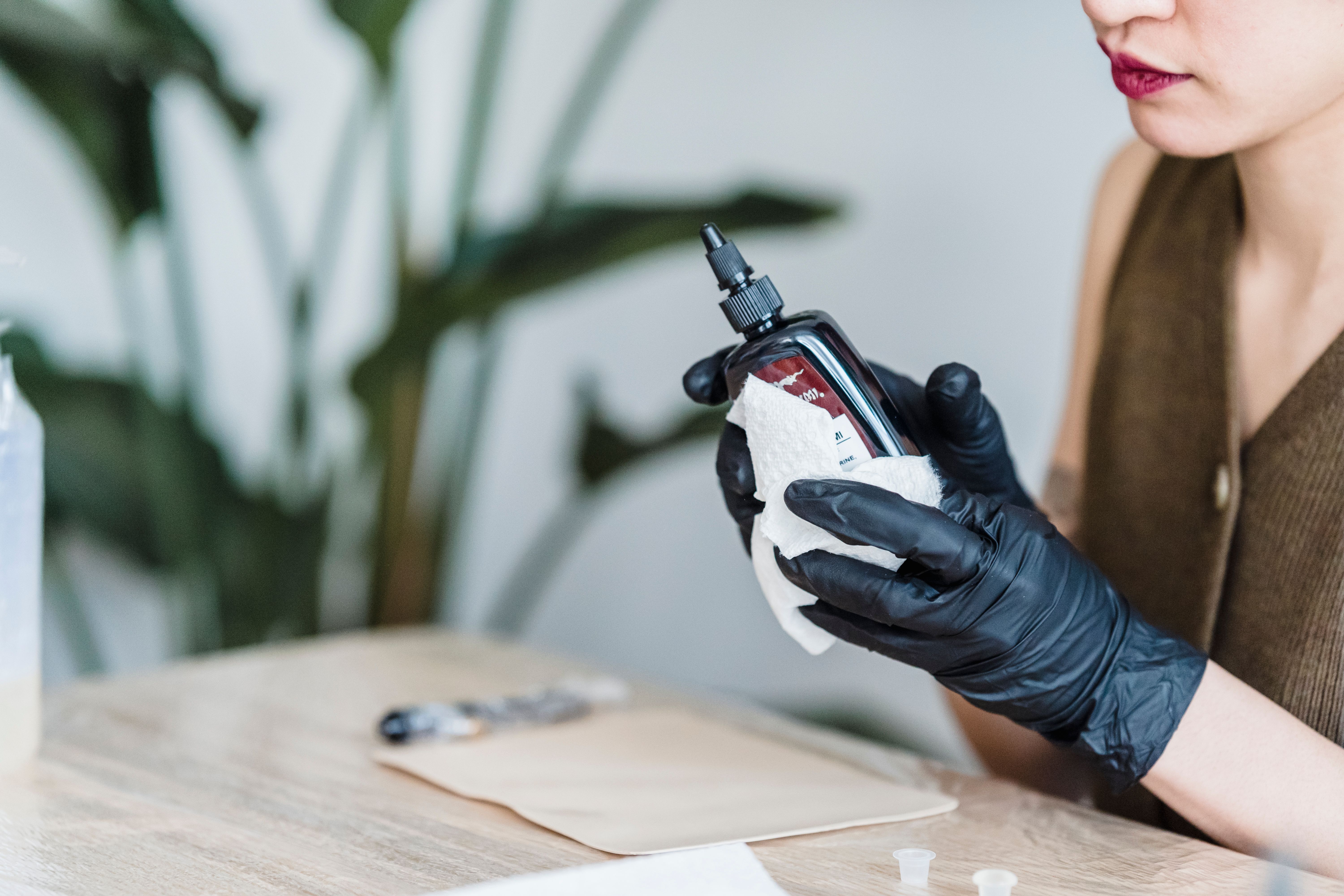 Tattoo artist wearing fresh gloves demonstrating proper hygiene during a session