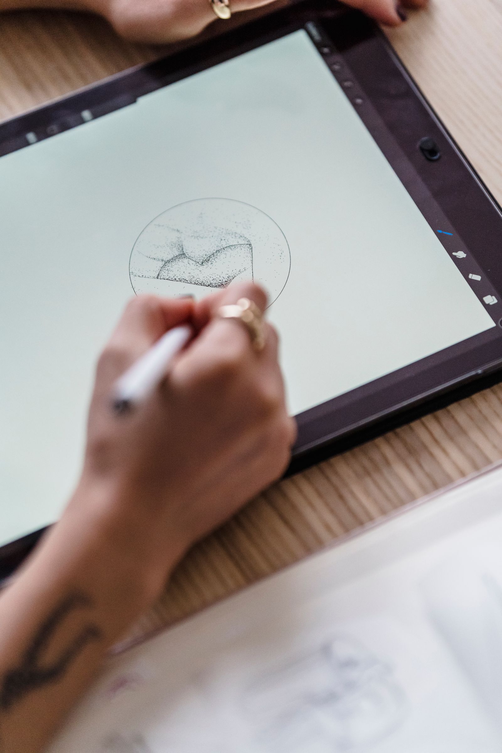 A designer sketching app screens on a tablet with a stylus