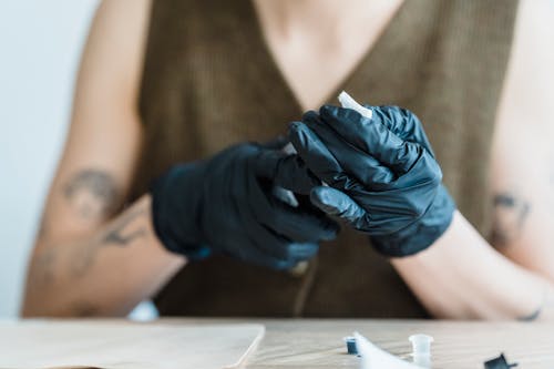 Free Person in Brown Sleeveless Top Wearing Black Gloves Stock Photo