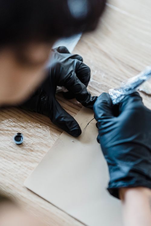 Free Tattoo artist expertly creating a design on a surface using ink. Focus on hands and technique. Stock Photo