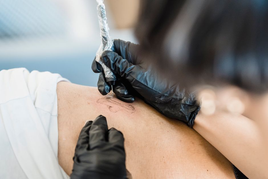 Tattoo Artist following sanitation and stencil steps during a professional tattoo session Tattoo Artist following sanitation and stencil steps during a professional tattoo session