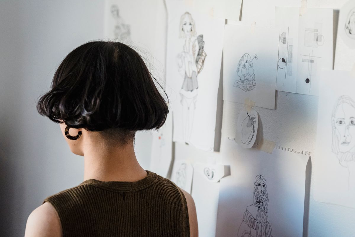 Designer reviewing a wall of component sketches — photo by Michael Burrows on Pexels
