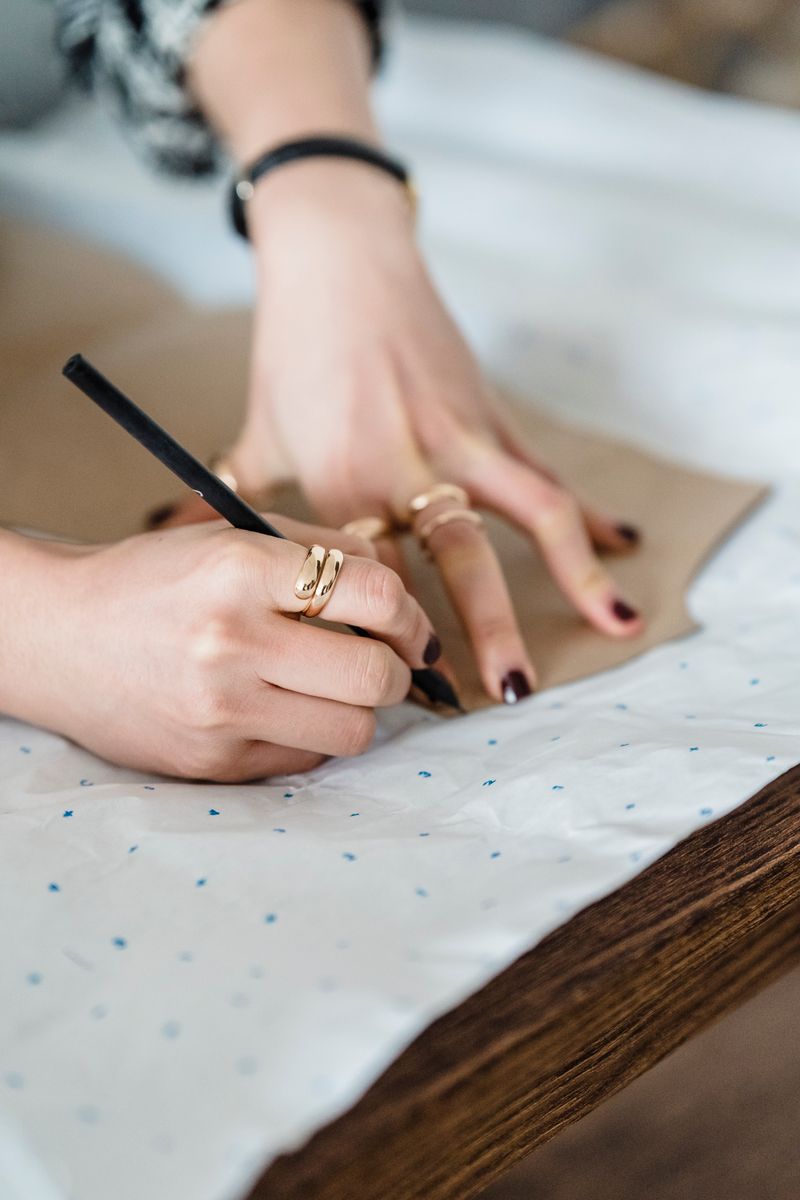 Lajwanti craftsman tracing garment patterns and leather construction