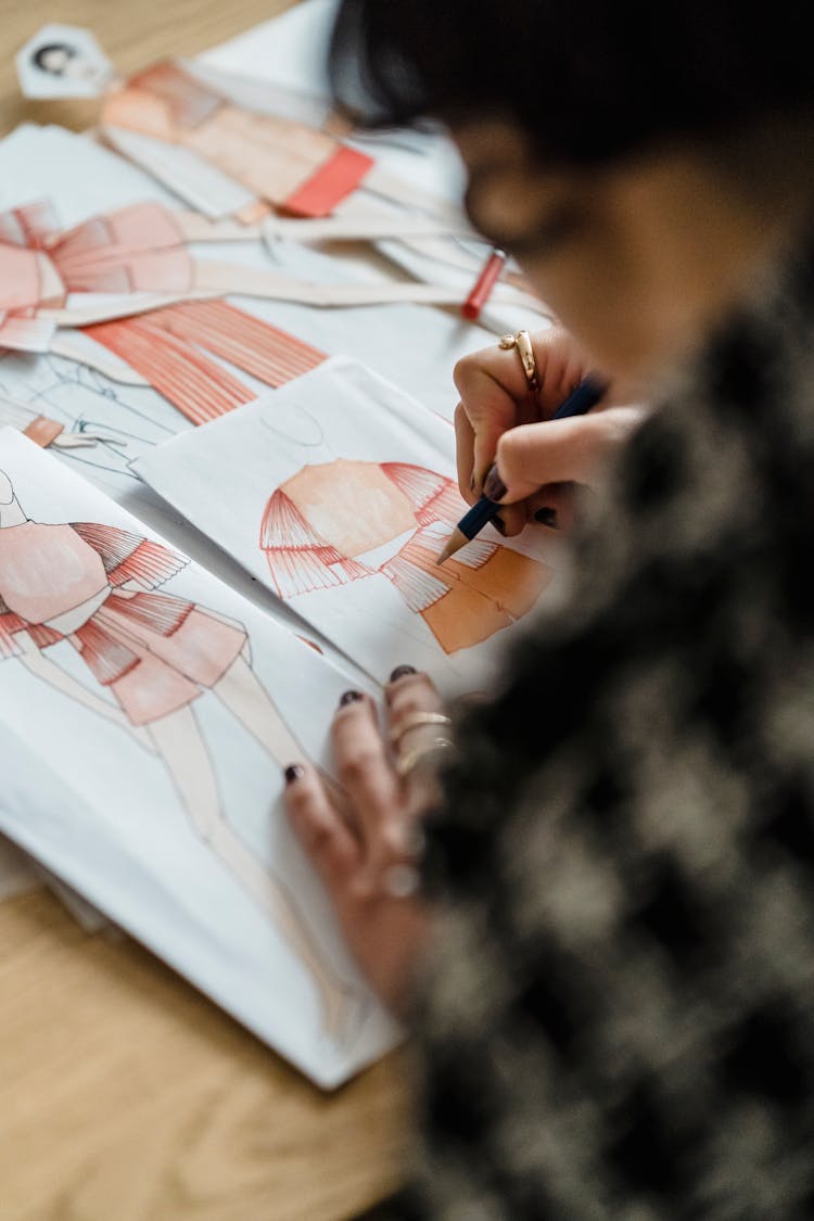 Tailor Making Sketches Of Clothes On Table