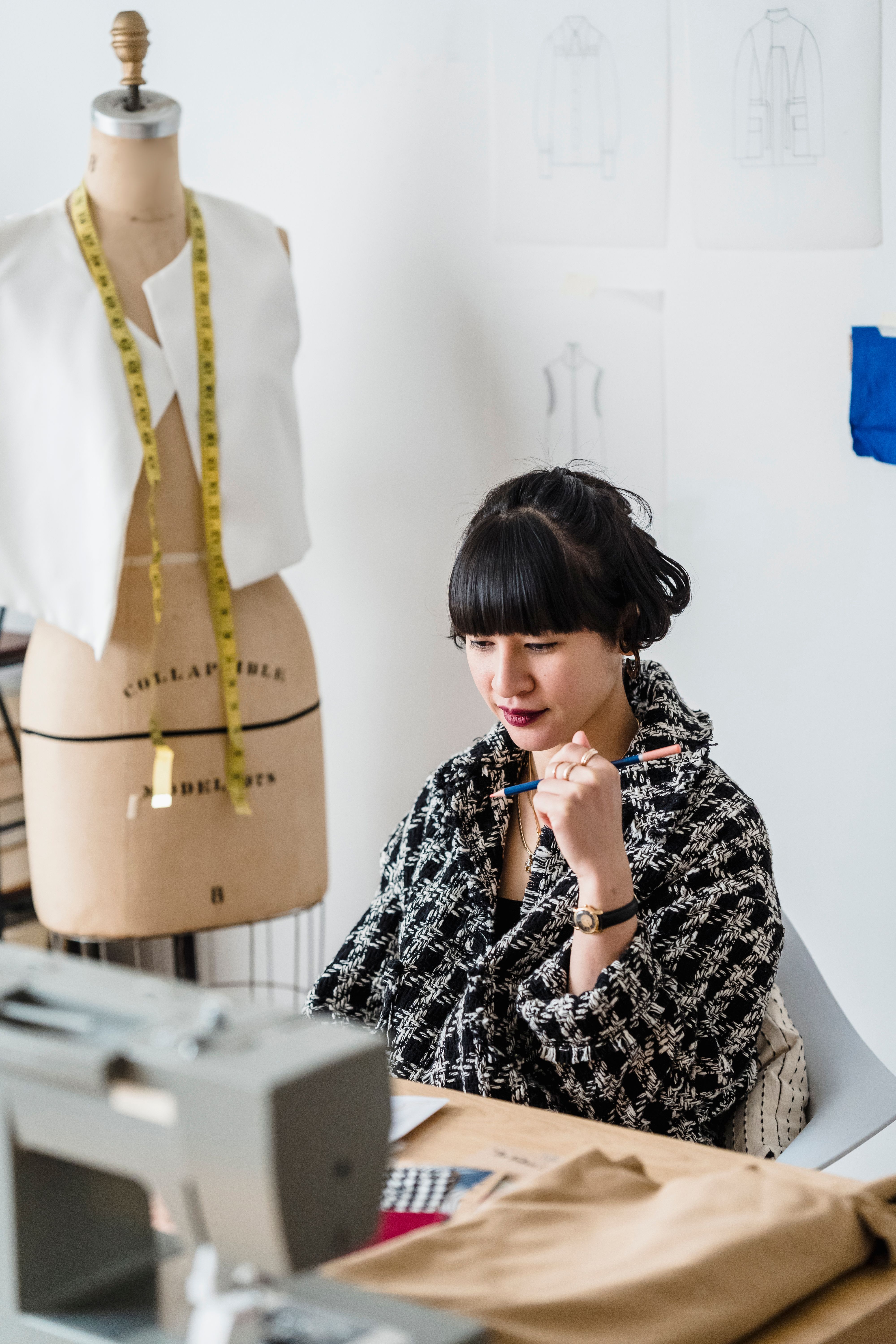 Illustrative photograph: Young Asian seamstress working in light atelier in daytime