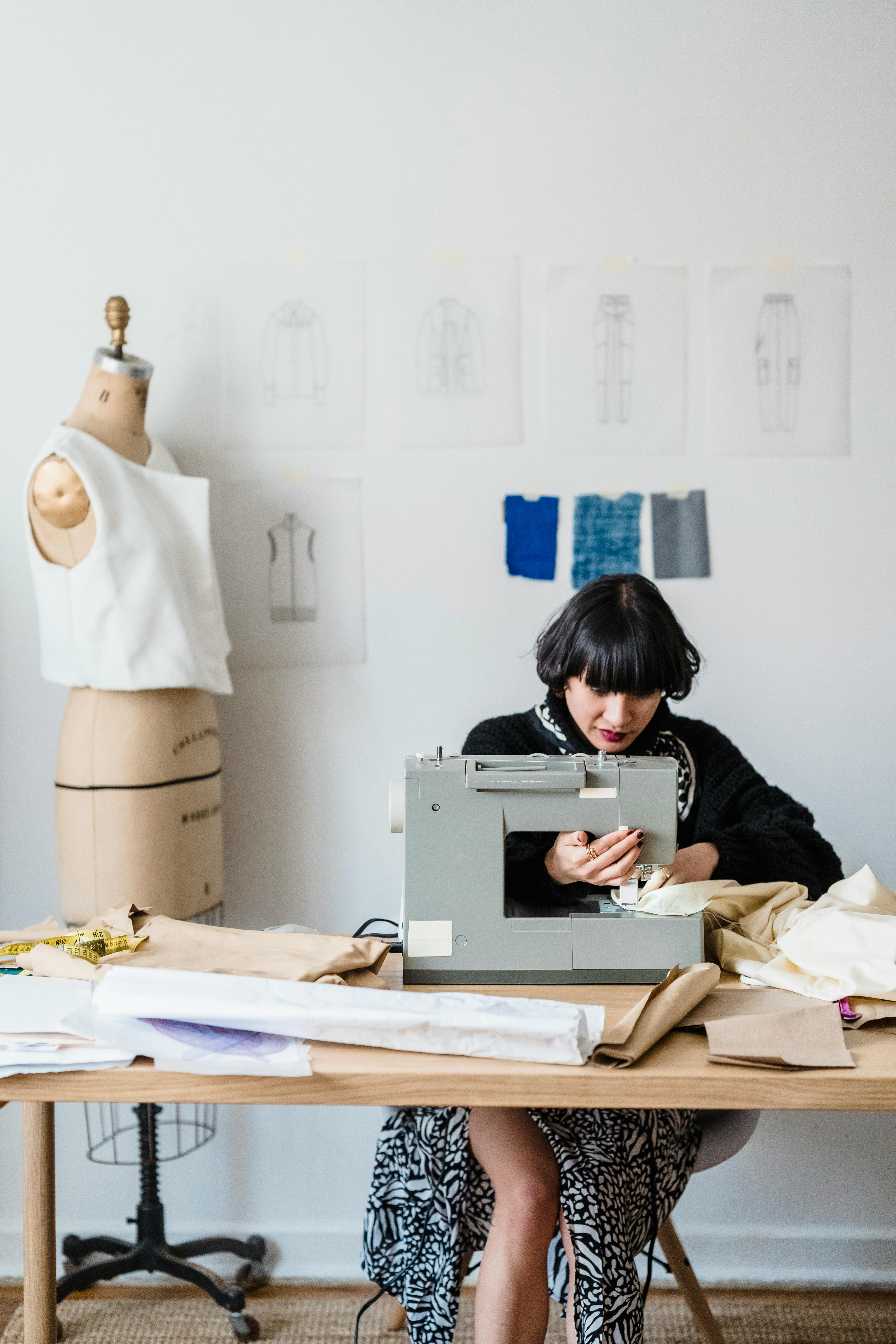 serious asian seamstress sewing in atelier in daytime