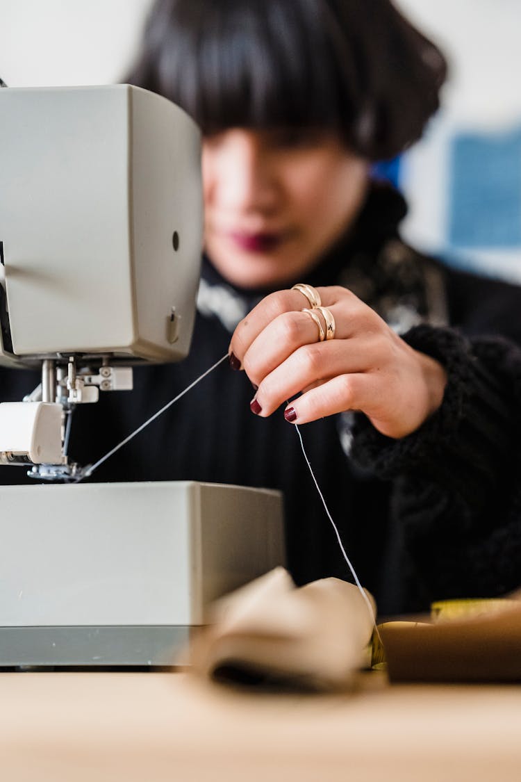 Female Seamstress Sewing During Work In Studio