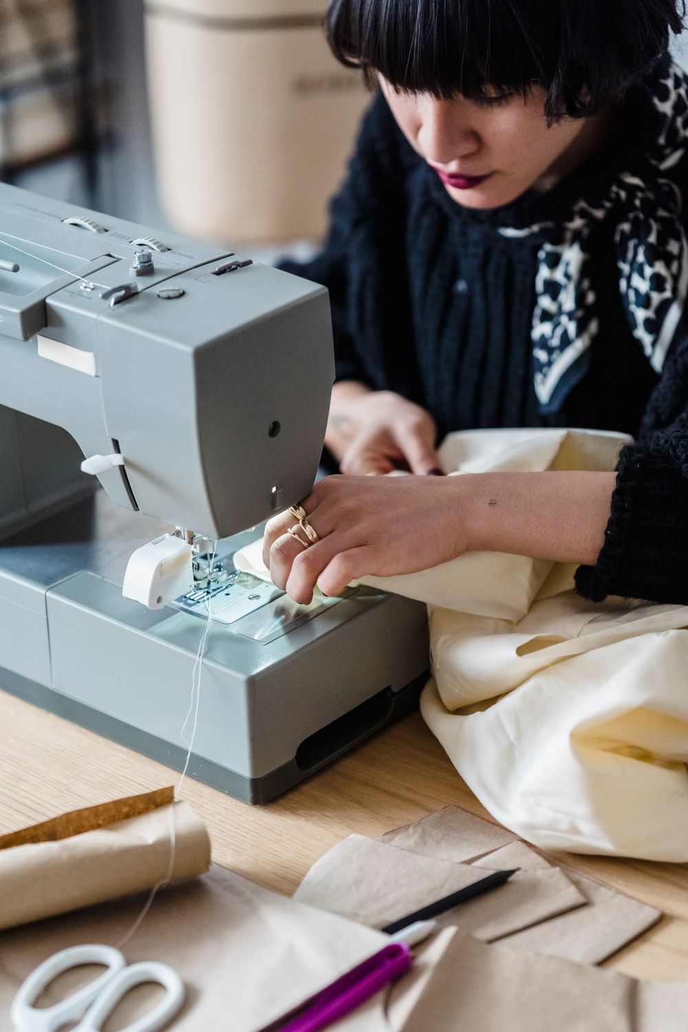 Hands guiding fabric through a sewing machine
