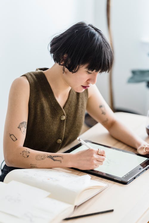 Young focused woman taking notes in tablet
