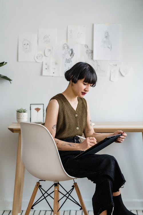 Young woman taking notes on tablet