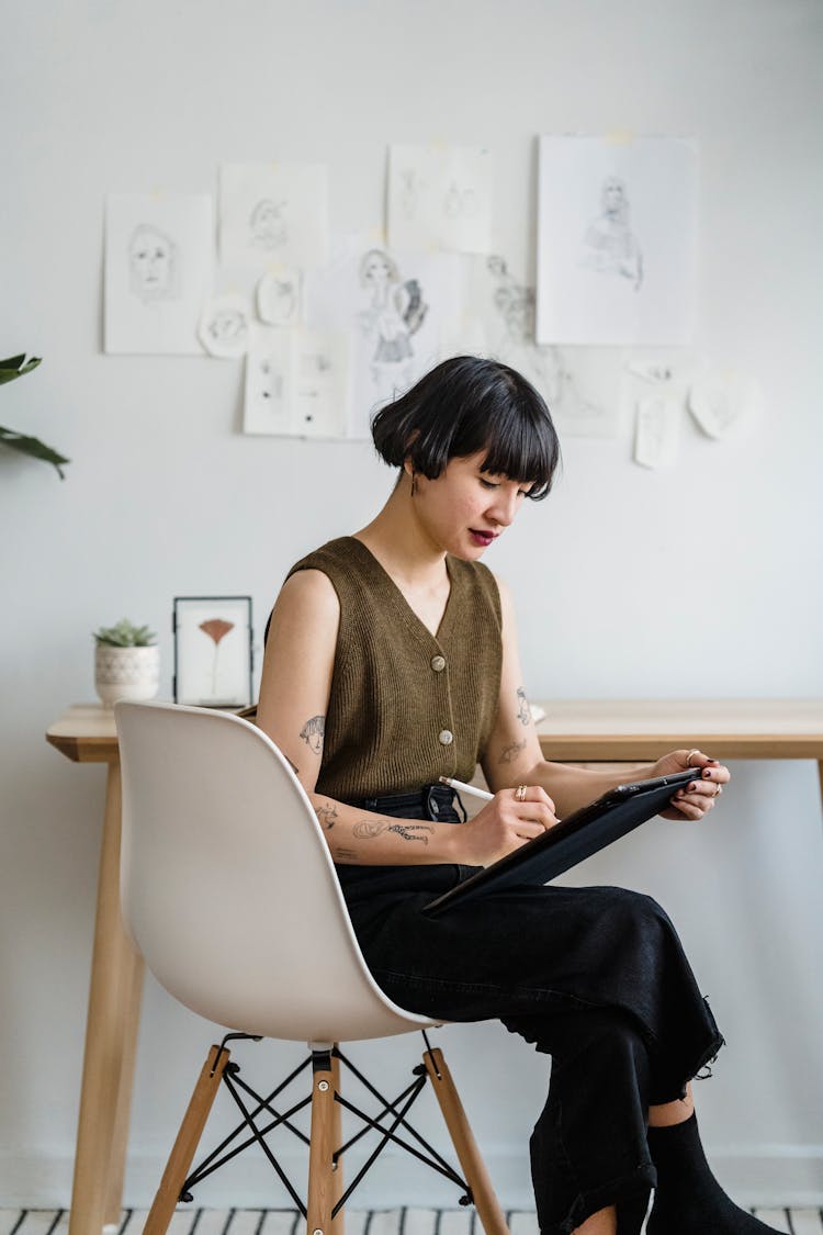 Young Woman Taking Notes On Tablet