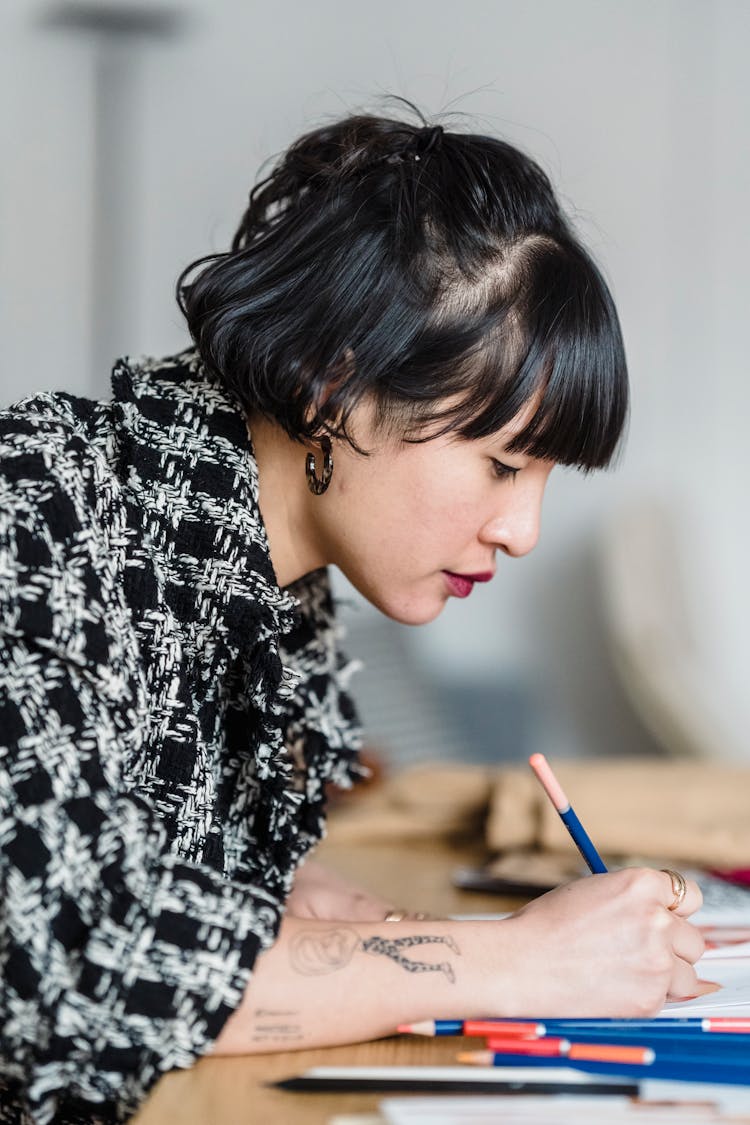 Focused Woman Drawing With Pencil