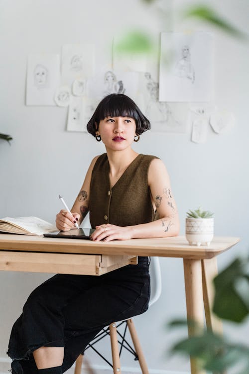 Pensive woman sitting in light workspace