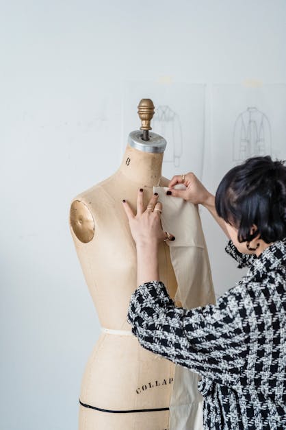 Woman trying on fabric on mannequin · Free Stock Photo
