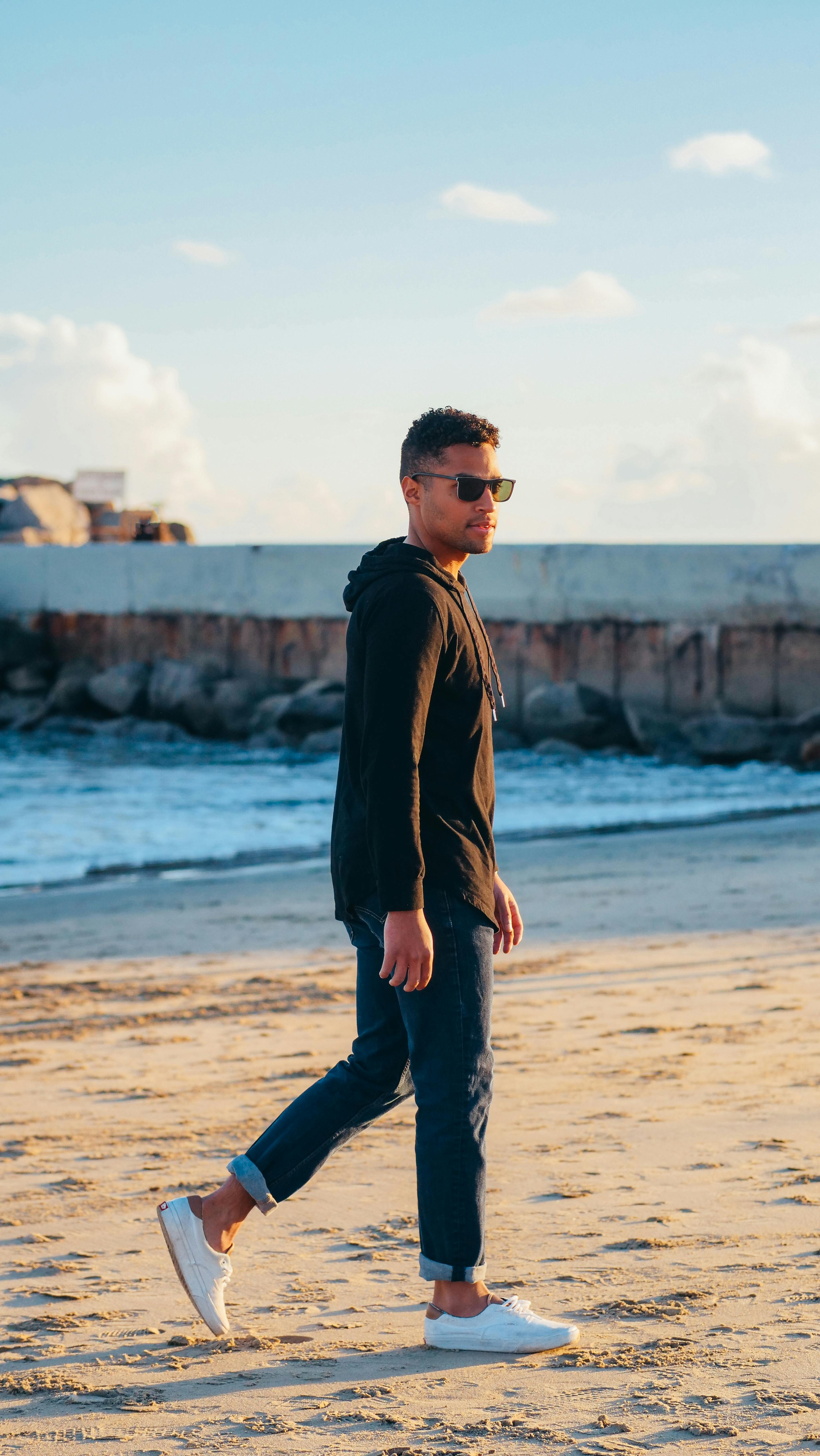 man standing on beach sand