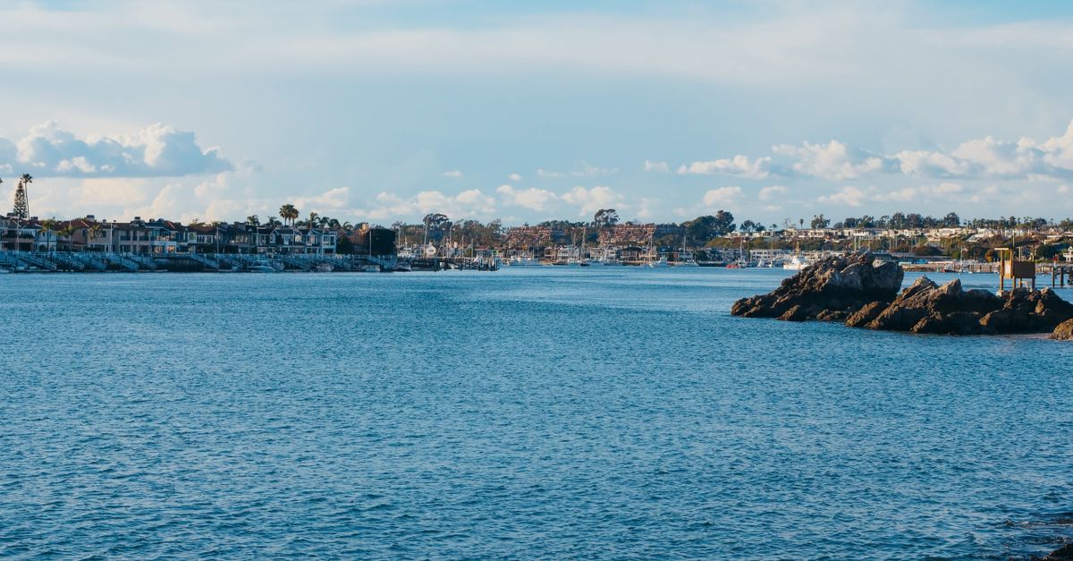 Scenic view of a coastal waterfront with a harbor under a clear blue sky.