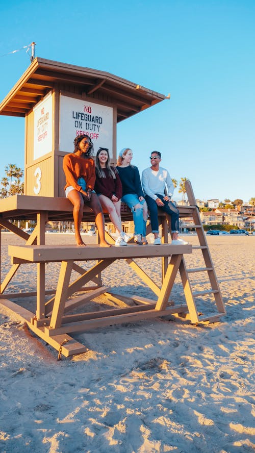 Free Group of Friends Sitting on Lifeguard Tower Stock Photo