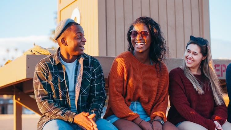 Two Women And A Man Laughing Together