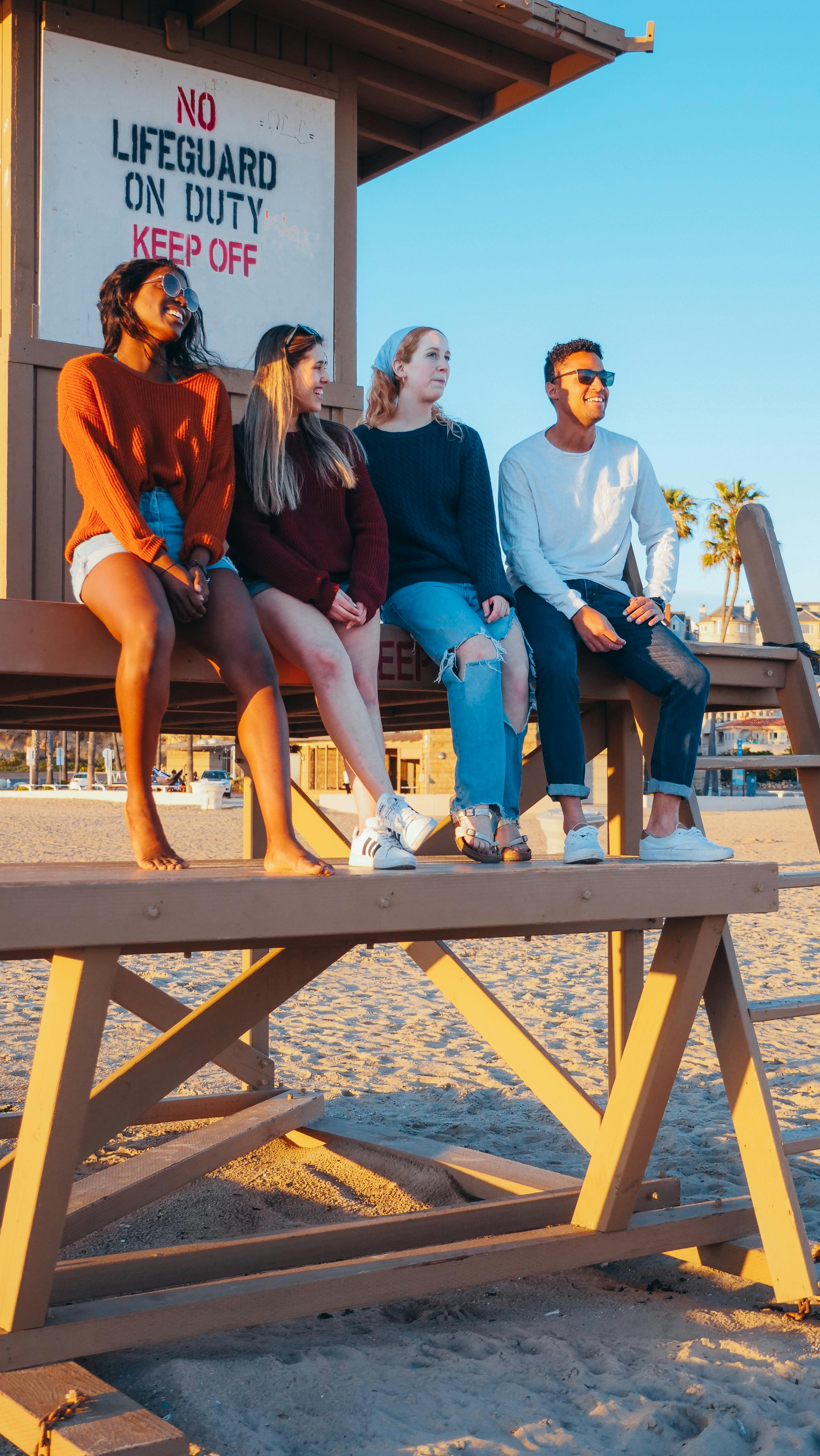 group of friends sitting on lifeguard tower