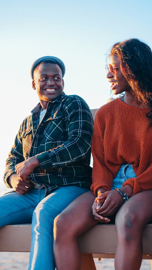 Man in Brown Plaid Button Up Shirt Sitting Beside Woman in Red Sweater