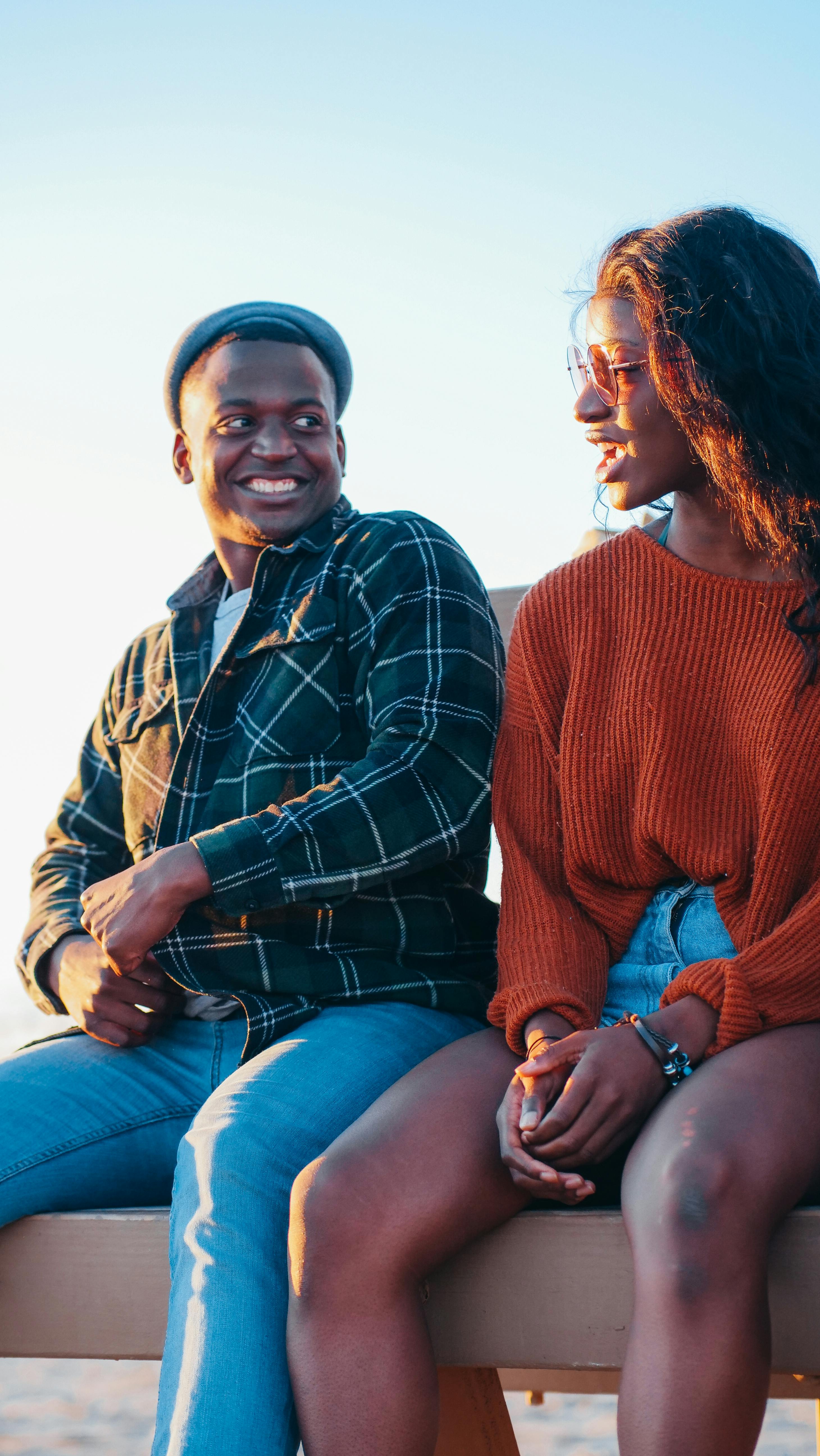 Woman and Man Sitting on Top of Brown Stone Fragment · Free Stock Photo