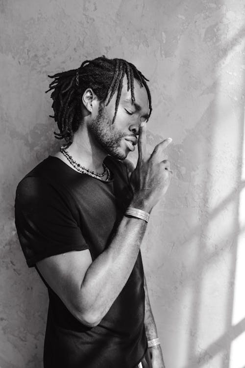 Grayscale Photo of a Man with Dreadlocks Posing