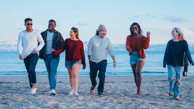 A diverse group of friends happily walking on the beach during sunset, embracing friendship and leisure.