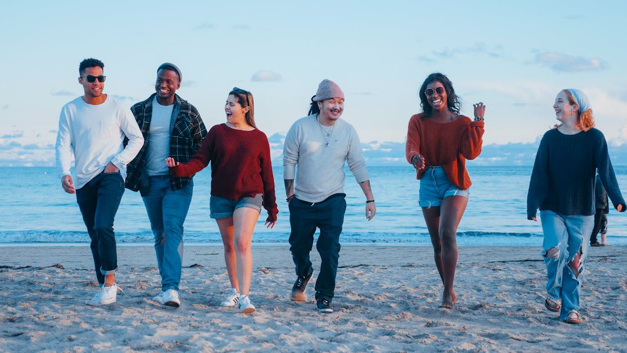 Free Group of Friends Walking on Beach Shore Stock Photo