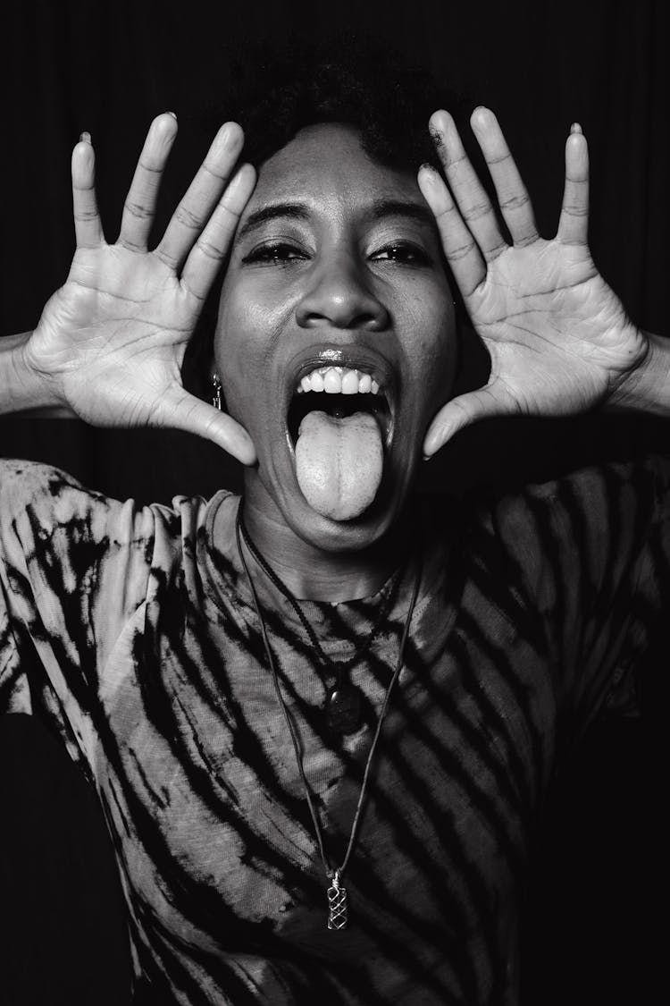 A Woman Showing Her Hands With Her Tongue Out