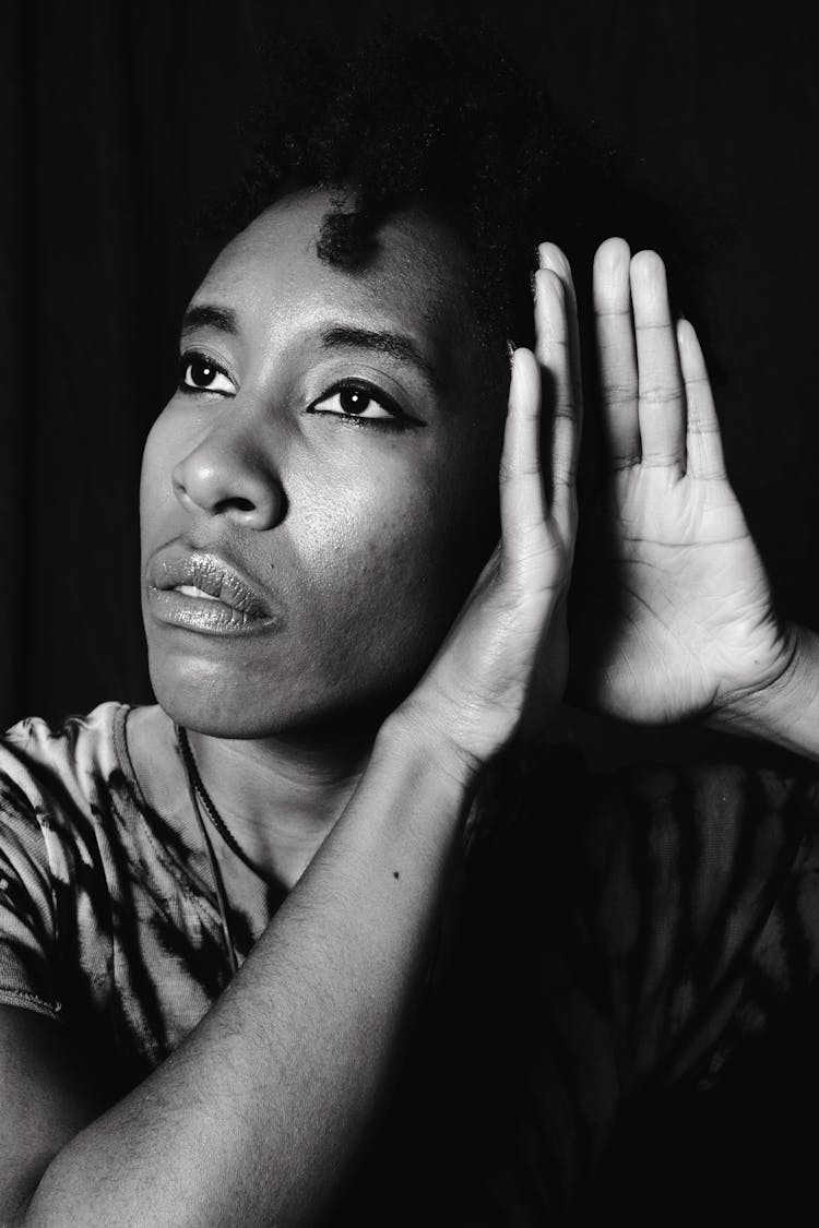 A Grayscale Photo Of A Woman In Hearing Position Of Her Hands