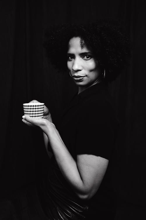 Grayscale Photo of a Woman Holding a Cup of  Coffee