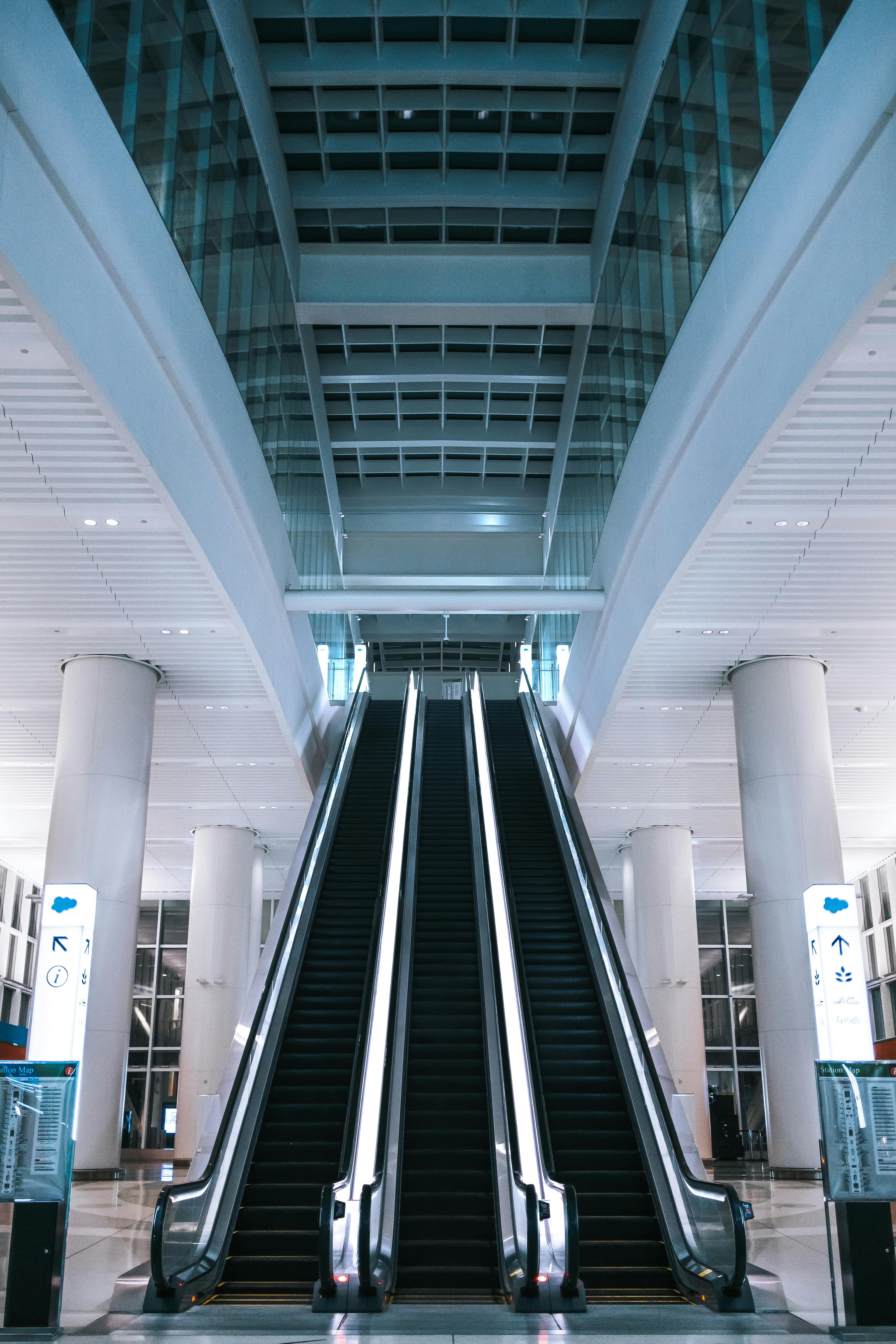 View of modern escalators in a spacious glass-panel interior, San Francisco.